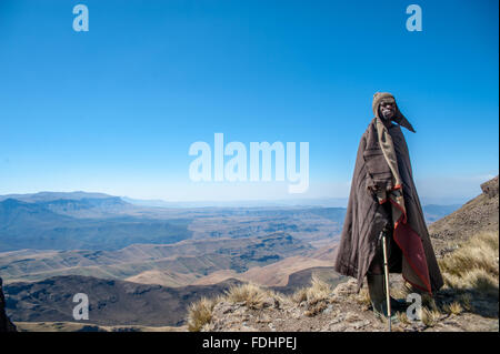 Hirte stehend vor einer Bergkette eingewickelt in Decken in Lesotho, Afrika Stockfoto