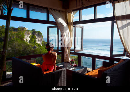 junge Frau, die auf dem Meer mit Blick auf einen Café, Bali, Indonesien Stockfoto