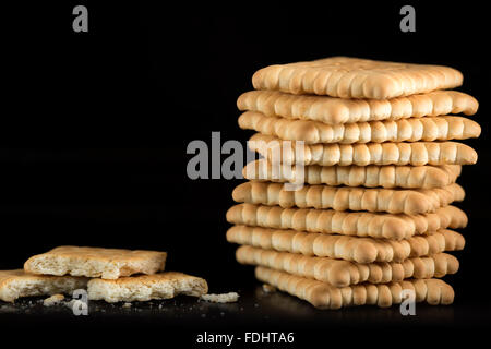 Stapel von knusprige Cracker vor schwarzem Hintergrund Stockfoto