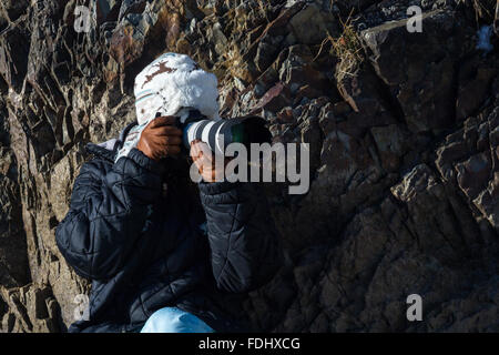 eine Frau in voller Winterbekleidung im winterlichen Bedingungen sicher und bereit zu fotografieren Stockfoto