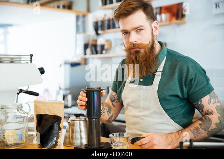 Hübscher junger Mann, die Zubereitung von Kaffee in Coffee-shop Stockfoto