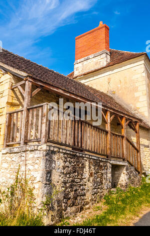 Traditionelles altes Steinhaus mit überdachten Balkon und neue Schornstein - Frankreich. Stockfoto