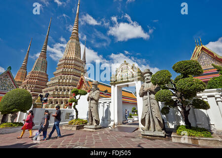Menschen, die am Phra Maha Chedi Si Rajakarn, den Großen Pagoden der vier Könige im Wat Pho Tempel, vorbei gehen. Bangkok, Thailand. Stockfoto