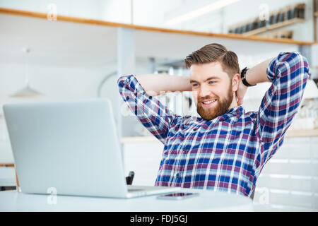 Glücklich entspannt Mann mit Laptop-Computer in Coffee-shop Stockfoto