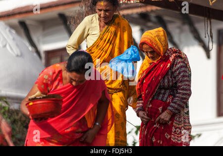 Drei Frauen tragen traditionellen nepalesischen Kleidung verlassen ihren Ort des Gebets während des Kumāri Jātrā-Festivals in Kathmandu Stockfoto
