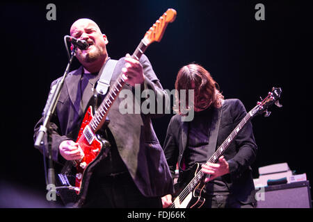 Alain Johannes singen und Gitarre spielen mit Dave Grohl im Hintergrund Stockfoto