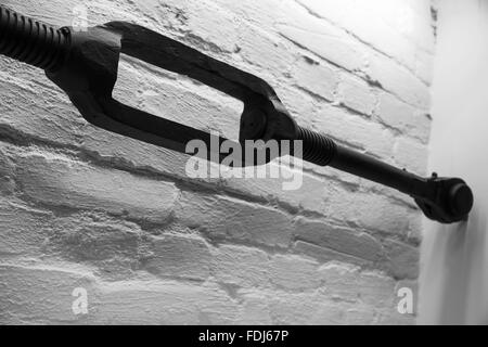 Alte schwarze Spannschloss, Nahaufnahme Foto über weiße Ziegel Wand Hintergrund Stockfoto