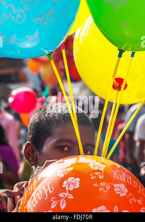 Ein Ballon-Verkäufer-junge bläst einen Ballon in Kathmandu Stockfoto