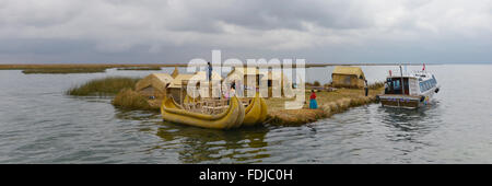 Titicacasee, Peru - 5. September 2015: Menschen vor Ort in traditionellen Gewändern willkommen Touristen kommen mit dem Boot auf den Inseln der Uros. Stockfoto