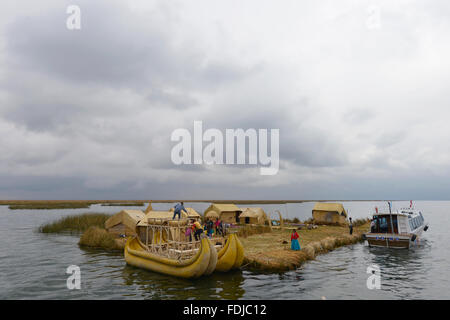 Titicacasee, Peru - 5. September 2015: Menschen vor Ort in traditionellen Gewändern willkommen Touristen kommen mit dem Boot auf den Inseln der Uros. Stockfoto