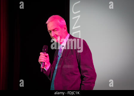 Britischer Journalist und neuen Moderator Jon Snow hält eine Mikrofon in elektrische Neon Farbe beleuchtet. Stockfoto