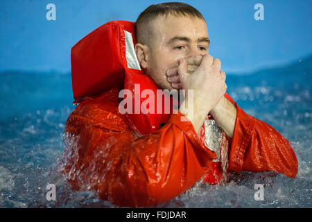 Ein Offshore-Arbeiter im Meer Überlebenstraining tragen einer Rettungsweste wieder auftaucht, während Meer Überlebenstraining. Stockfoto