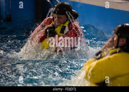 Ein Offshore-Arbeiter im Meer Überlebenstraining tragen einer Rettungsweste wieder auftaucht, während Meer Überlebenstraining. Stockfoto