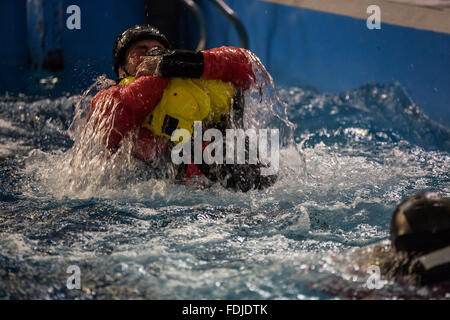 Ein Offshore-Arbeiter im Meer Überlebenstraining tragen einer Rettungsweste wieder auftaucht, während Meer Überlebenstraining. Stockfoto