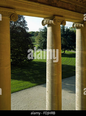 Ein Blick auf die Einfahrt durch die ionischen Säulen des eingelassenen Portikus an der Westfront von Basildon Park, Berkshire. Stockfoto