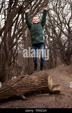 Junge abspringen Baumstamm im Wald, Sofia, Bulgarien Stockfoto