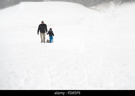 Vater und Sohn wandern im Schnee Stockfoto