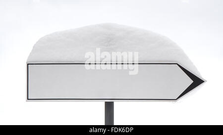 Weiße leere Blechschild post zeigt eine richtige Richtung mit einem Schnee-Hut auf es nach starkem Schneefall. Stockfoto