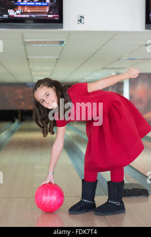 Mädchen mit Bowling-Kugel auf Bowling-Bahn Stockfoto