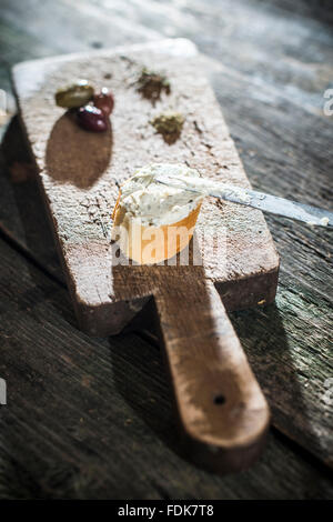 Bruschetta mit weicher Frischkäse und Oliven auf Schneidebrett Stockfoto