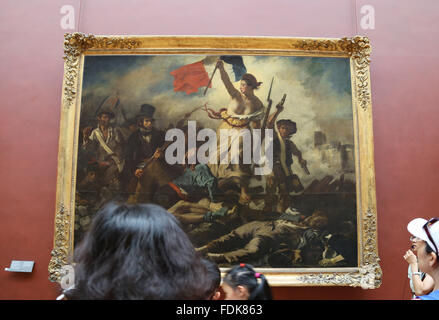 Tourist im Louvre-Museum.  Freiheit führt das Volk, 1831. Von Eugene Delacroix. Paris. Stockfoto