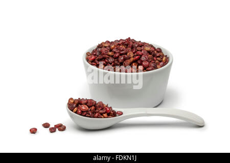 Getrockneten Sumac Beeren in eine Tasse und Löffel auf weißem Hintergrund Stockfoto