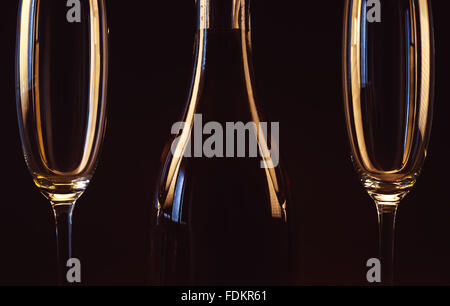 Zwei leere Gläser und eine Flasche Spirituose auf braunem Hintergrund. Stockfoto