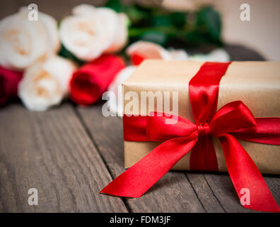 Geschenkbox mit Bewegungsunschärfe roten und weißen Rosen auf einem dunklen Hintergrund aus Holz. Frauen ' s Tag, Valentinstag, Muttertag. Textfreiraum, sel Stockfoto