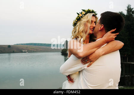 Braut in einem Armen des Bräutigams Stockfoto