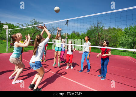 Mädchen und Jungen spielen gemeinsam volleyball Stockfoto