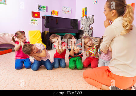 Kinder spielen Spiel vorgeben werden schlafend mit Lehrer Stockfoto