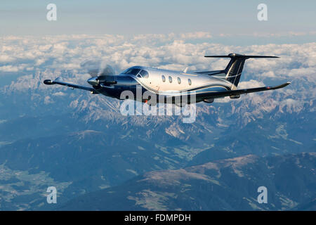 Einmotoriges Turboprop-Flugzeuge fliegen über die Alpen in Österreich. Stockfoto