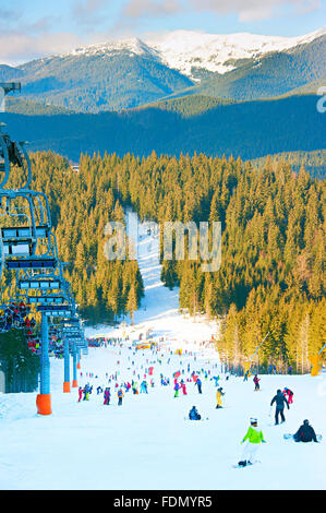 Menschen, Skifahren und Snowboarden am Hang im Skigebiet Stockfoto