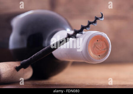 alte Vintage Korkenzieher und eine Flasche Wein auf Holzbrett Stockfoto