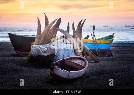 Fishermens Booten und traditionellen Fischerei Kanus (Caballitos de Totora) hochgezogen am Strand von Pimentel in Nord-Peru Stockfoto