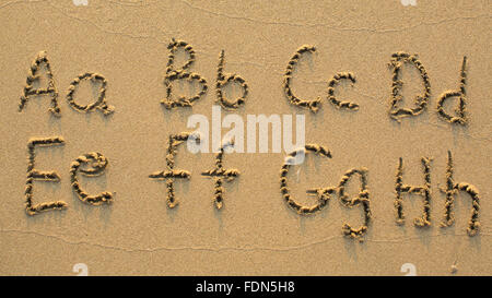 Buchstaben des Alphabets geschrieben am Sandstrand (von A bis H) Stockfoto