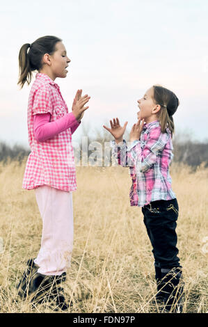 Mädchen im Feld spielen Händeklatschen Spiele Stockfoto