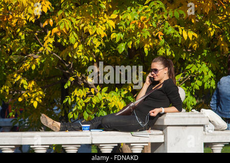 Junge Frau am Handy im Alexandergarten, Moskau, Russland Stockfoto
