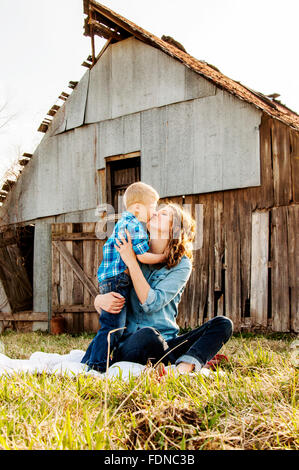 Mutter und Sohn küssen und umarmen Scheune Hintergrund Stockfoto