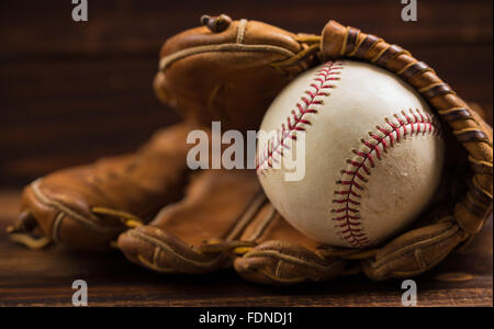 Braun Leder Baseballhandschuh auf einer Holzbank Stockfoto