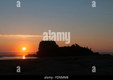 Menschen auf der Kapelle Rock, Dünenwanderungen Strand, Perranporth, Cornwall, UK. Sonnenuntergang. Juli. Flut heraus. Stockfoto