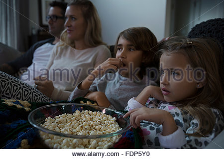 Familie mit Popcorn Film im Wohnzimmer