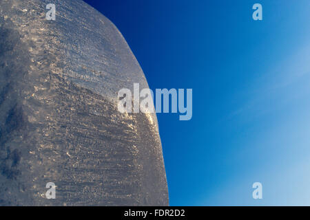 Schöne transparente Eisblock mit glitzernden Wasser Tropfen Satz gegen ein strahlend blauer klarer Himmel. Kopieren Sie Raum. Bild für Getränke Stockfoto