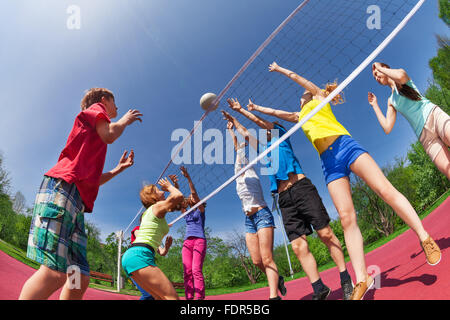 Jugendliche, die auf dem Spiel Platz Volleyball spielen Stockfoto