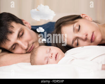 Baby schläft mit müde Eltern Stockfoto