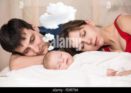 Baby schläft mit müde Eltern Stockfoto