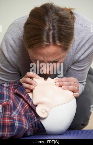 Frau In erste-Hilfe-Kurs durchführen von Mund zu Mund Beatmung auf Dummy Stockfoto