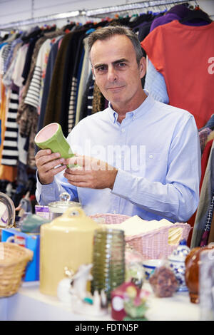 Männlichen Shopper im Secondhand-Laden schauen Ornamente Stockfoto