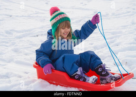 Kleines Mädchen Rodeln bergab in Neverland Spielpark, Kirriemuir, Schottland, 2016 Stockfoto