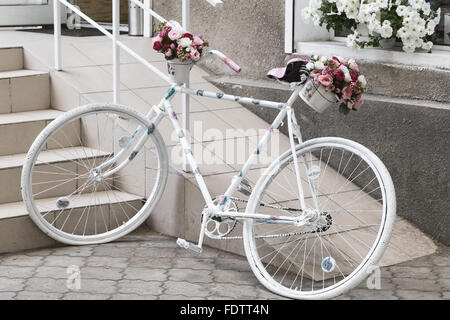 Kreativen Blumenstrauß bunte künstliche auf alten weißen Fahrrad. Raum in der Zone Unschärfe Zusammensetzung und selektiven Fokus Stockfoto